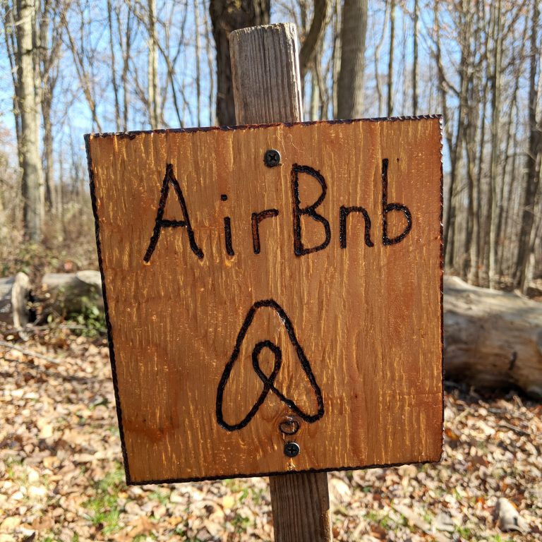 A homemade wood-burned sign welcomes us to the farm