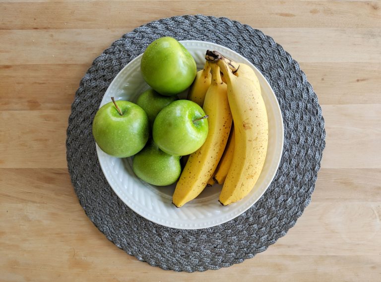 green apples and bananas in a fruit bowl