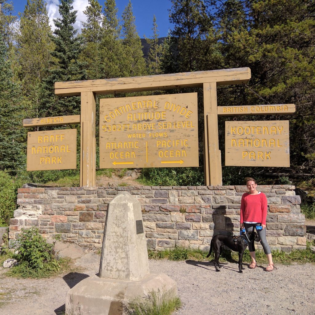 Erin and Odin at Banff National Park at the continental divide sign