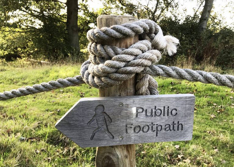 sign for public footpaths cows in countryside pasture in Benenden, England
