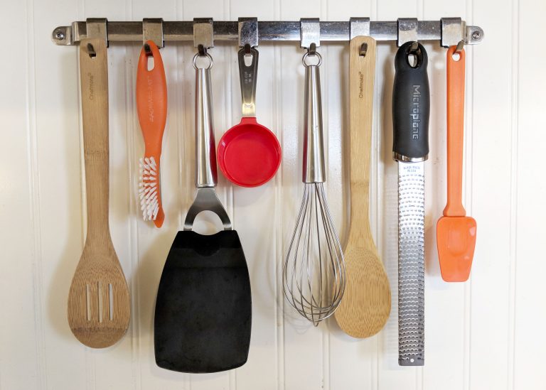 kitchen utensils hanging from a metal rack