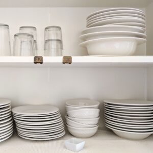 white dishes stacked in a cabinet